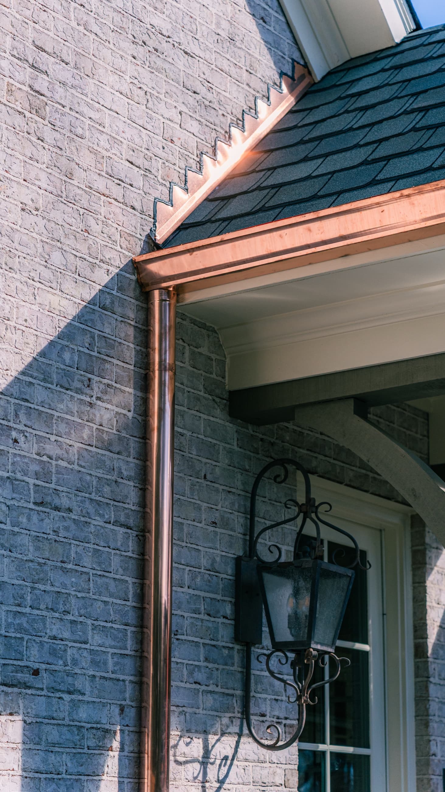 Copper-trimmed portico and slate hip roof on a Charlotte home installed by Manchester Roofing