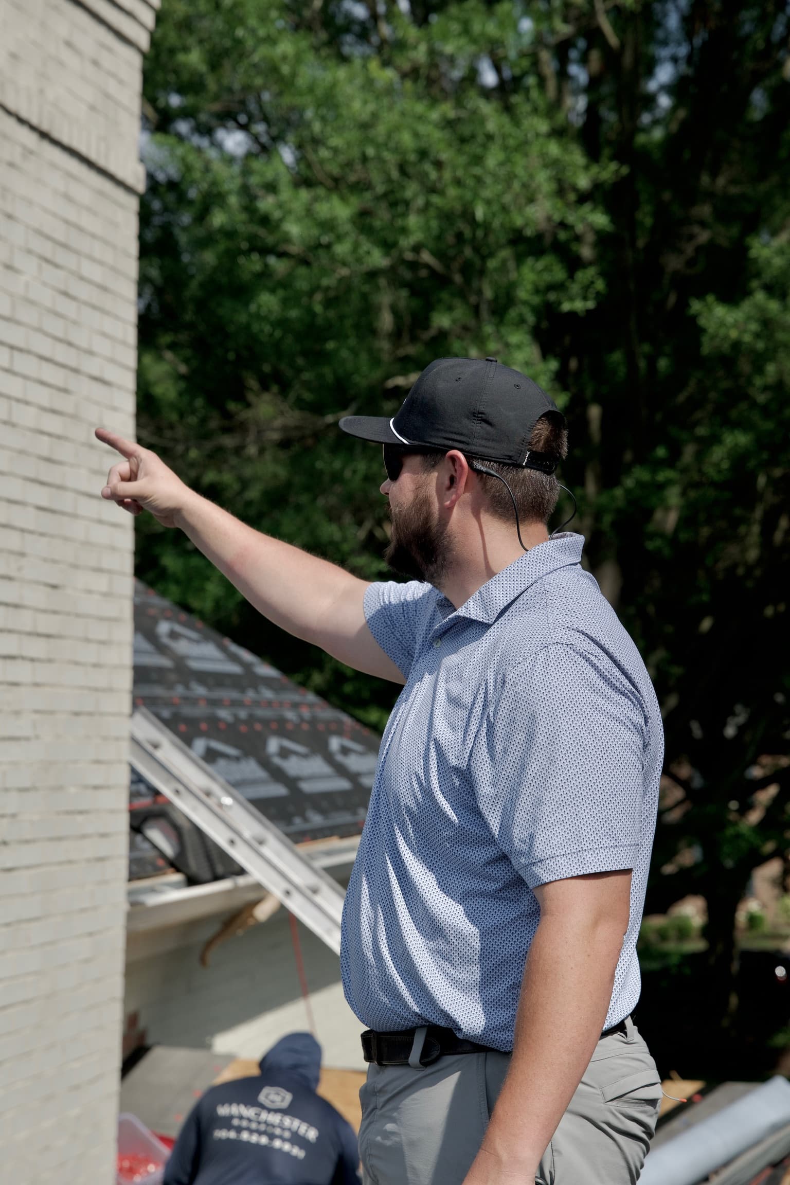 Will LeGrand, founder of Manchester Roofing, inspecting a chimney flashing detail on a Charlotte-area residential roof.